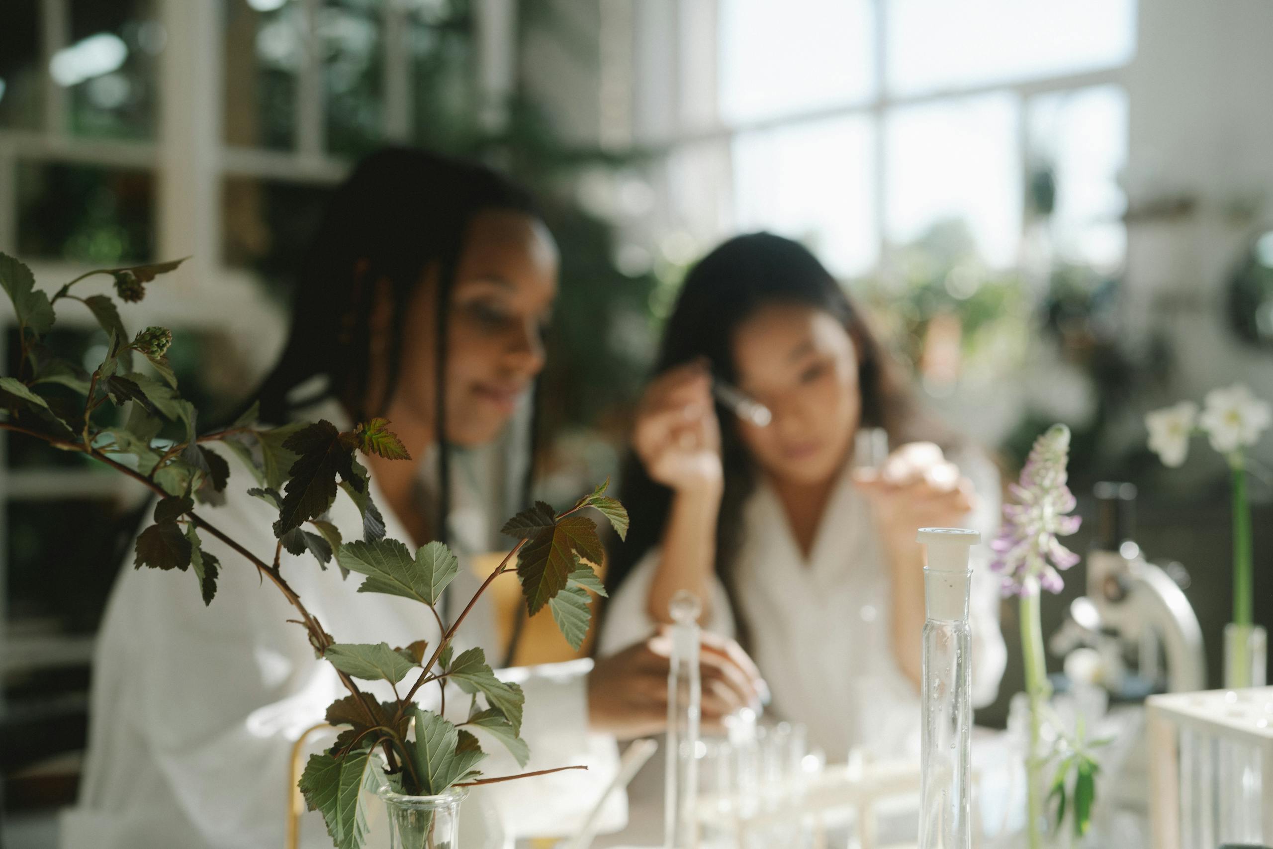 Two scientists working with plants in a bright laboratory environment.
